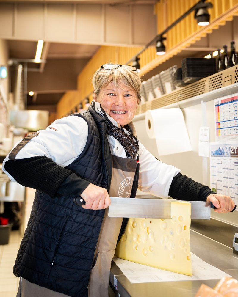 Fromagère d'Intermarché Faverges coupant une meule au rayon traditionnel