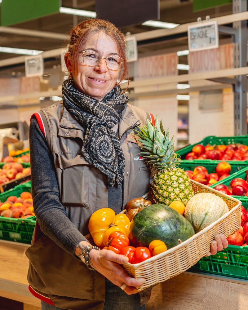Responsable fruits et légumes d'Intermarché Faverges avec un panier de produits frais