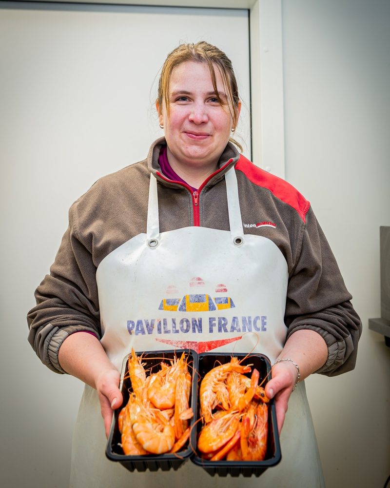 Poissonnière d'Intermarché Faverges présentant des gambas Pavillon France